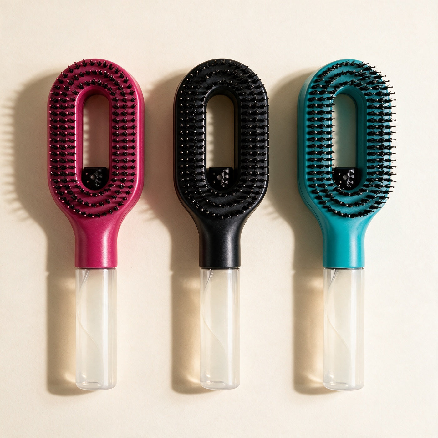 Les trois coloris de la brosse Soalia : rose framboise, noir et bleu